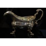 GIII silver sauce boat with gadrooned border, scroll handle, shell knees and feet, London 1767,