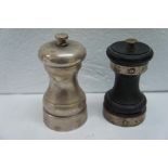 Two black pepper grinders, silver and silver and ebony. Ht 3.7 ins.