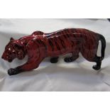 A Royal Doulton flambe Tiger by Noke, length 13.5ins