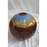 A Peter Layton circular glass vase in blue, ochre and brown swirl glass, signed, height 7 ins.,