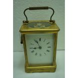 Edwardian brass four-glass striking carriage clock with white enamel dial by Howell, James and