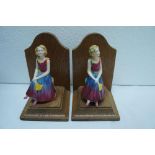 Pair of oak bookends, each mounted with Goss figures of "Daisy". Ht. 5.5 ins.