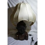 A Far Eastern table lamp in the form of a bronzed metal Buddha's head on hardwood base with raw silk