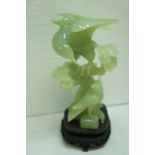 Chinese carved jadeite eagle on a branch on carved hardwood stand. Ht. 10 ins.