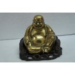 Chinese brass seated fatman on carved hardwood base. Ht. 5 ins.