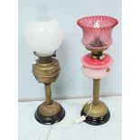 Two Victorian brass oil lamps, one with ruby glass shade.