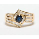 An 18ct gold three row crossover ring claw set with a central sapphire and channel set with one