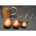 A copper rum measure together with three graduated copper ladles.