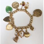 A 9ct gold charm bracelet, set with 11 charms and a heart shaped clasp. Total weight: 50.5 grams.