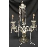 A large cut and faceted glass two light candelabra, strung with cut glass prisms and supported on