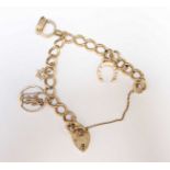 A 9ct gold charm bracelet, set with four charms and heart shaped clasp. 31 grams.