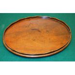 A small antique mahogany oval tray, with a serpentine edge gallery, on later pad feet. 13.5in (