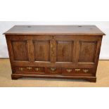 An eighteenth century oak mule chest, the hinged lidded top above a fielded panel front and three