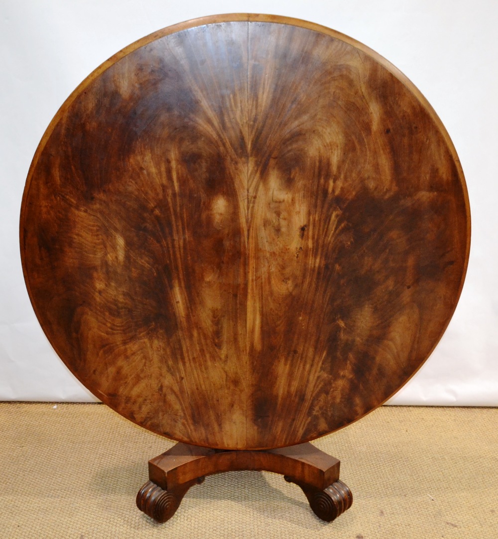A William IV mahogany loo table, with well figured veneered circular tilt top on a facetted