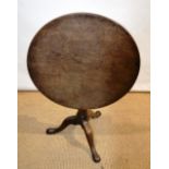 A George II Cuban mahogany occasional table, the circular tilt top revolving on a baluster bird