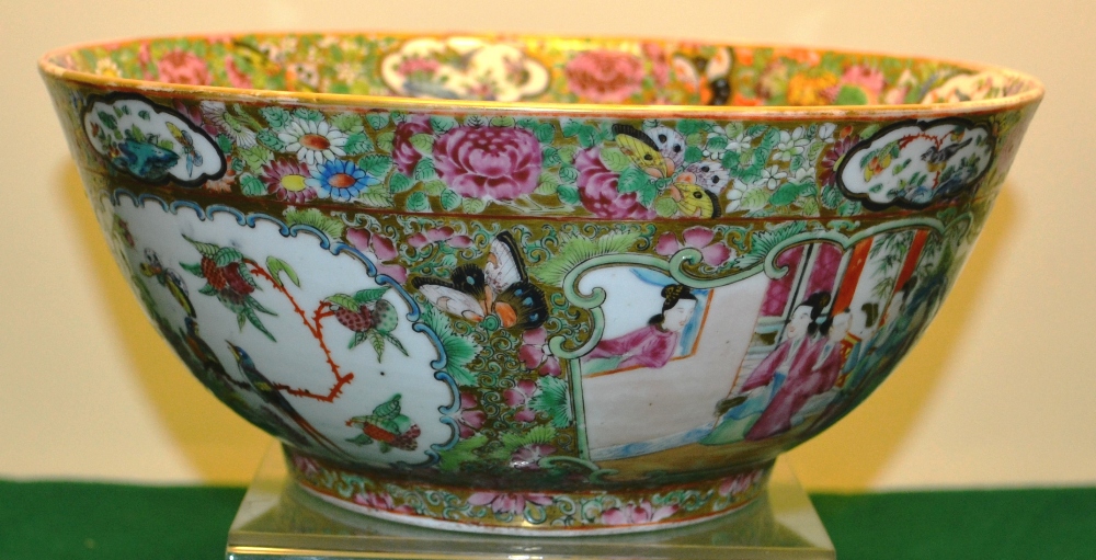 A nineteenth century Cantonese porcelain punch bowl, decorated in famille rose enamels court