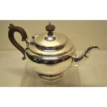 A silver circular teapot, with a collared swan neck spout, a laurel banded border, the hinged