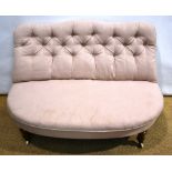 A Victorian couch, the buttoned back to a 'D' shape sprung seat on turned walnut legs with