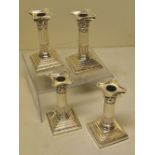Two pairs of Victorian silver candlesticks, with stop fluted stems and corinthian repousse
