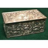 A late Victorian silver casket, with repousse hatched scrolls and cartouches, the hinged lid