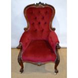 An early Victorian mahogany show frame armchair, the buttoned back with pierced rococo spray
