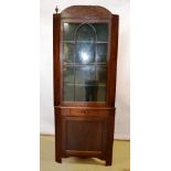 A mahogany standing corner display cupboard, the raised outline panel pediment with finials, above s