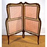 An early Victorian rosewood two fold screen, with a rococo foliage carved scroll channelled frame, f