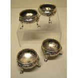 A set of four Regency silver salts, with repousse foliage and gadroon borders, on shell appliqué