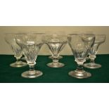 Eight early nineteenth century glass rummers, the panel cut flared bowls on a circular foot.