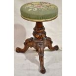 An early Victorian rosewood music stool, with a needlework padded adjustable seat, on a turned