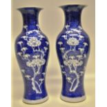 A pair of late nineteenth century Chinese waisted blue and white porcelain vases, decorated prunus