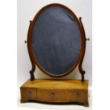 A Sheraton Revival mahogany toilet mirror, inlaid stringing, the oval swing glass on scroll