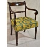 A Regency mahogany elbow chair, the curved rope rail back with a scroll leaf carved crest, the