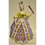 A nineteenth century porcelain figure of a lady wearing a feather hat and floral dress with a