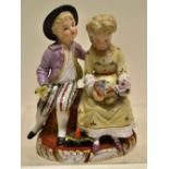 A late nineteenth century Sitzendorf porcelain group of a young couple, seated on a bank, each