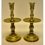 A pair of early eighteenth century Dutch brass candlesticks with baluster turned stems with