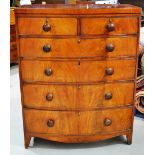 An early nineteenth century mahogany veneered tall bow front chest, the frieze with ebony