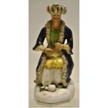 An early nineteenth century Staffordshire figure of a seated Turk, with a pot at his feet and