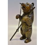 A nineteenth century Black Forest carved wood dancing bear, with glass eyes and a brass pole on a