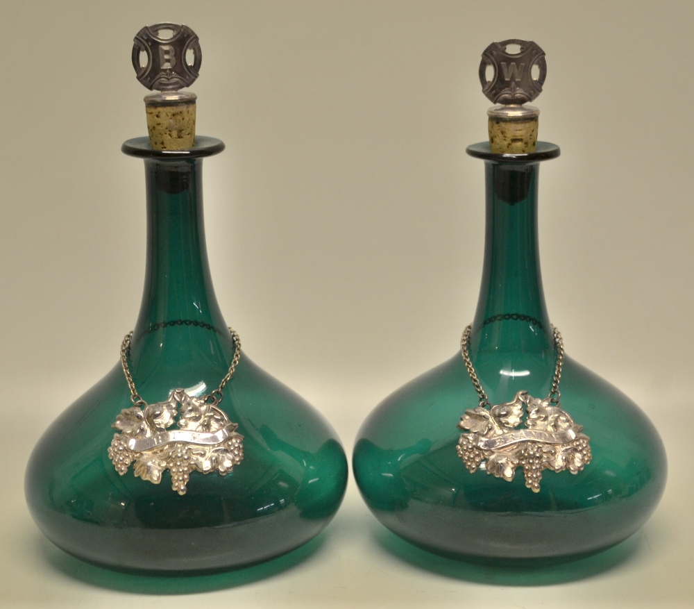 A pair of Victorian green glass ships decanters, with plated top cork stoppers, initialled B & W (