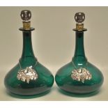 A pair of Victorian green glass ships decanters, with plated top cork stoppers, initialled B & W (