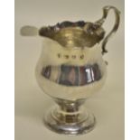 A George III silver inverted pear shape cream jug, with a fret edge rim and leaf capped scroll