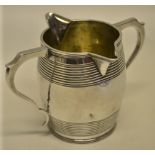 A Regency silver double lipped cream jug, with reeded banded barrel shape body and two bracket