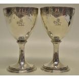 A pair of George III silver wine goblets, the bowls engraved a crest and initials gilded