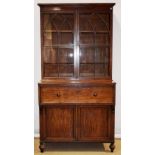 An early nineteenth century fiddle back mahogany secretaire bookcase, the moulded cornice above