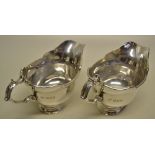 A pair of silver sauce boats, in early George II style, having shaped moulded rims and cast