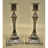 A pair of late Victorian silver candlesticks in Neo Classical style, the Greek key fluted