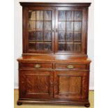 A late Victorian Liberty oak library bookcase, the top with a moulded cornice, three adjustable