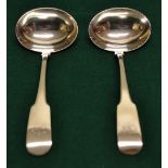 A pair of Regency Irish silver fiddle pattern sauce ladles, engraved initials, with oval bowls.