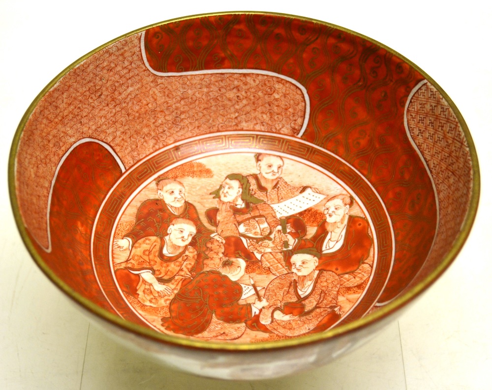 A Japanese red decorated porcelain bowl of a lion standing by bamboo and two horses frolicking in